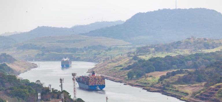 container ship driving through the panama canal, panama city, panama.