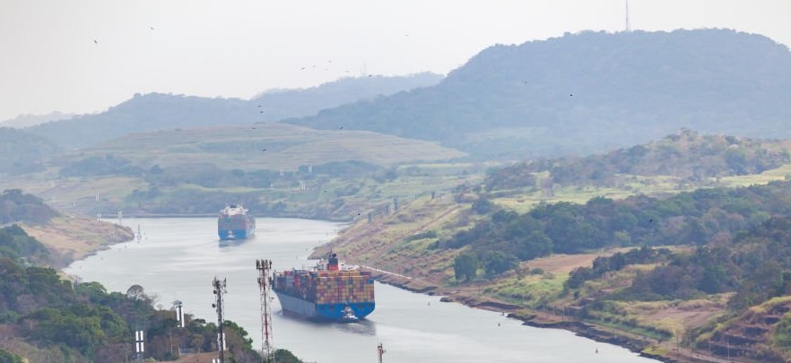 container ship driving through the panama canal, panama city, panama.